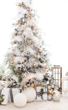 a white christmas tree with presents under it