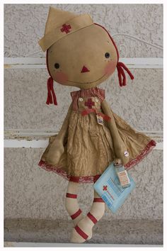 a stuffed doll is wearing a dress and holding a book