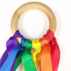 a rainbow colored wooden ring with ribbon around it