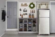 a white refrigerator freezer sitting inside of a kitchen next to a wall mounted shoe rack