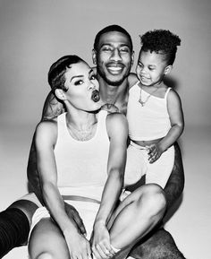 a black and white photo of a man, woman and child sitting on the floor