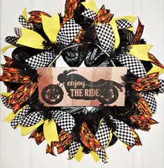 a black and yellow wreath with a sign that says enjoy the ride