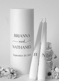 two white candles sitting next to each other