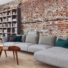 a living room filled with furniture and a brick wall