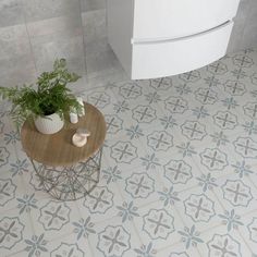 a white toilet sitting next to a wooden table with a plant on top of it