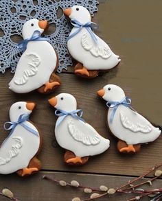 four decorated cookies sitting on top of a wooden table