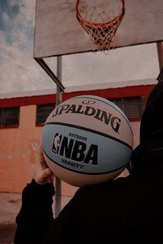 a person is holding a basketball in front of a hoop with the word spalding on it