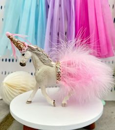 a white horse with pink feathers on it's back