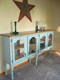 a blue cabinet with glass doors and a star on the wall above it in a living room