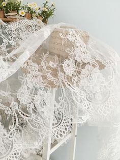 white lace with flowers on it sitting on a shelf