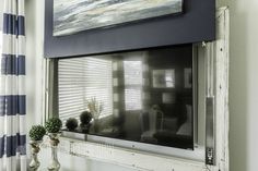 two vases are sitting on a table in front of a window that has blue and white striped curtains