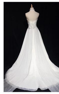 a white wedding dress on a mannequin with sheer tulle overlays