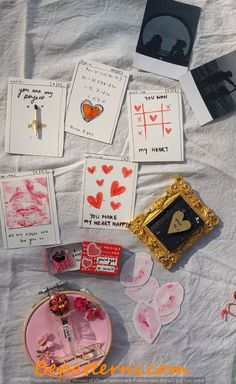 some cards and pictures are laying on a table with white cloth, scissors, and other items