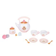 a toy tea set with cups and saucers on the table, including a pink kettle