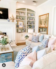 a living room filled with furniture and a fire place in front of a white fireplace