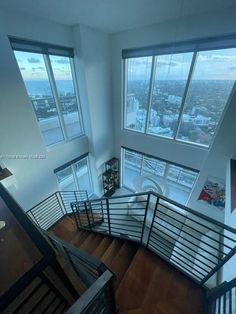 a view from the top of a stair case looking down at some windows and buildings