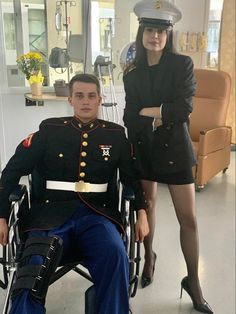 a woman standing next to a man in a wheelchair