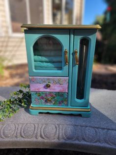 a small blue cabinet sitting on top of a cement slab