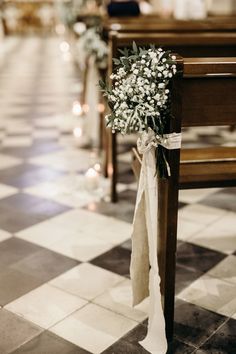 a bouquet of flowers is tied to the pews