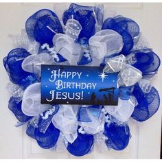 a blue and white wreath with the words happy birthday jesus on it, hanging on a door