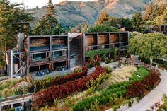 an aerial view of a house surrounded by trees and mountains