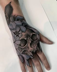 a hand with a skull and flowers on it