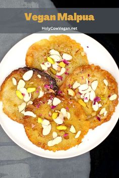 a white plate topped with three desserts covered in almonds and pistachio