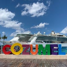 a large cruise ship docked in the water behind a colorful sign that says'welcome to columbus '