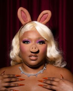 a woman with bunny ears on her head and nails in front of her face, posing for the camera