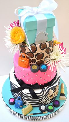 a multi - tiered cake decorated with leopard print and accessories