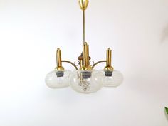 three light chandelier with glass globes hanging from it's brass finish