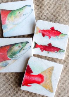 four coasters with fish painted on them