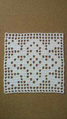 a white crocheted doily sitting on top of a brown table next to a wall