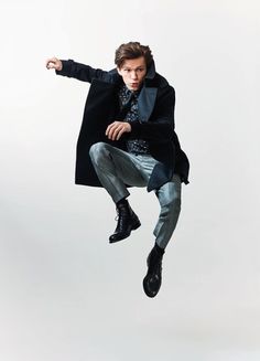 the man is jumping in the air with his coat on