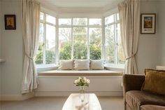 a living room filled with furniture and windows