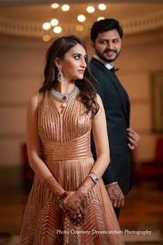 a man and woman standing next to each other in formal wear, posing for the camera