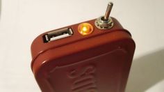 a red lighter with two yellow lights on it's side and a white wall in the background