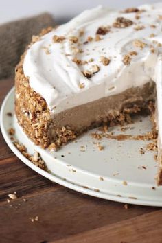 a white plate topped with a cake covered in frosting and crumbled toppings