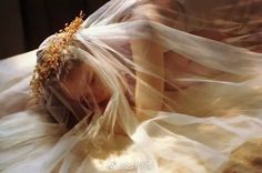 a woman wearing a veil on top of a bed