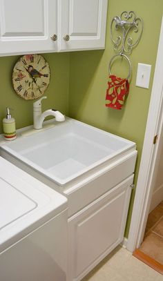 a white washer sitting next to a dryer in a room with green walls