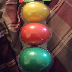 three plastic balls sitting on top of a bed