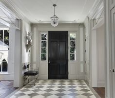 an entryway with a checkered floor and black door