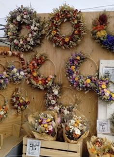 several wreaths are hanging on the wall with flowers in them and other decorations around them