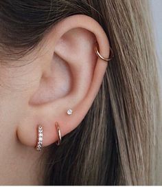 a close up of a person's ear with two different types of piercings