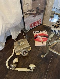 an old fashioned telephone is on the floor next to a mirror and other items that have been placed in front of it