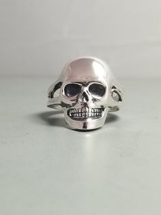 "*MAY SLIGHTLY DIFFER FROM PICTURES AS EACH ONE IS HANDMADE* .925 Solid Sterling Silver Handmade Skull Ring With Split Shank AMERICAN MADE Each ring is handmade and can be made any size The Weight will vary depending on size (A Size 7 Weighs Approximately 10 Grams) We have sold many rings around the world and each is custom made through a Lost Wax casting process using a hand cut master pattern Each ring is hand crafted and is stamped on the inside \"STER\" This ring will come with a black ring Black Ring Box, Sugar Skull Ring, Many Rings, Handmade Skulls, Small Skull, Black Ring, Lost Wax Casting, Split Shank, Skull Ring