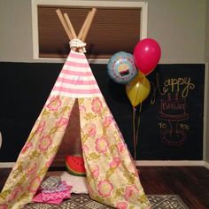 a teepee tent with balloons on the floor