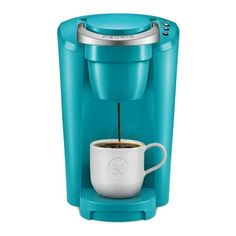 a blue coffee maker with a white cup