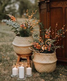 two baskets with flowers and candles on the ground