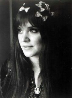 black and white photograph of a woman with long hair wearing butterflies in her hair, looking at the camera